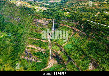 Splendida vista aerea di una cascata che si getta attraverso le lussureggianti scogliere verdi di Barichara, Santander, Colombia, mostrando bellezza naturale e serenità. Foto Stock