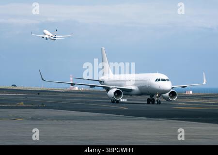 Due aerei commerciali all'aeroporto: Uno in rullaggio, uno in decollo Foto Stock