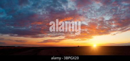 Nuvole rosse perfette illuminate dai raggi del sole. Immagine panoramica del cielo strutturato. Foto del concetto di ecologia. Sfondo naturale mozzafiato Foto Stock