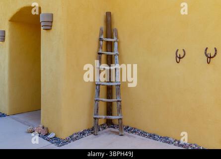 Rustica scala Kiva in legno adagiata su un'architettura in stile pueblo sud-ovest di adobe Foto Stock