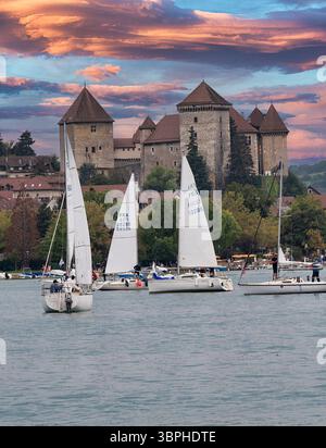 Le barche a vela sono molto popolari sul lago di Annecy nelle Alpi francesi, lo storico castello d'Annecy si affaccia sulla città e sulla foresta alpina circostante, Annecy, Foto Stock