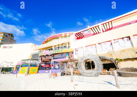 Vista sulla spiaggia dell'ingresso del Coco Bongo Beach Club nella zona degli hotel di Cancun, presa da Playa Chacmool. L'immagine mostra la facciata iconica e colorata Foto Stock