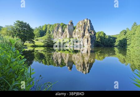 L'Externsteine, una formazione rocciosa di arenaria alta circa 40 metri nella foresta di Teutoburgo, è un punto di riferimento naturale e un ambiente naturale protetto e culturale Foto Stock