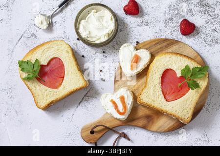 Colazione per san valentino o per la festa della mamma, brindisi con salmone e formaggio con l'iscrizione che ti amo. Vista dall'alto, disposizione piatta Foto Stock