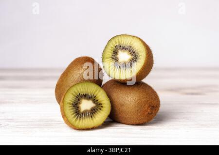 Kiwi fette su un tavolo di legno bianco, cibo sano, dieta di frutta Foto Stock