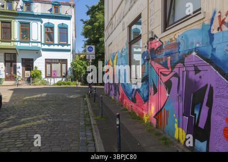 Strada residenziale nel quartiere di Ostertor, una popolare area residenziale, sobborgo orientale, edificio in stile Wilhelminian, facciata colorata, graffiti, traffico si Foto Stock