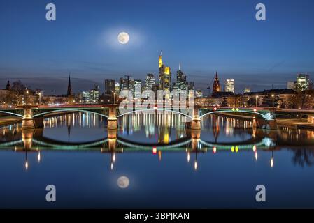 Il centro della città di Francoforte sul meno, visto dal fiume meno di sera, con la luna piena riflessa sulla superficie dell'acqua, Francoforte sul meno, GE Foto Stock