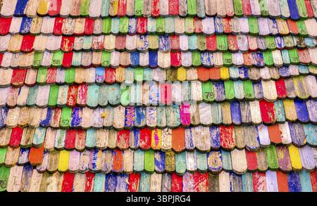 Tegole colorate e leggermente intemprate sotto forma di code di castoro con numeri parzialmente stampati Foto Stock