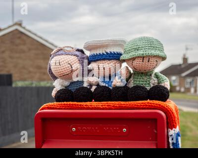 Topper a maglia con un aviere, un marinaio e un soldato per commemorare il VE Day, villaggio di Hackleton, Northamptonshire, Regno Unito Foto Stock