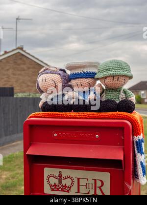 Topper a maglia con un aviere, un marinaio e un soldato per commemorare il VE Day, villaggio di Hackleton, Northamptonshire, Regno Unito Foto Stock