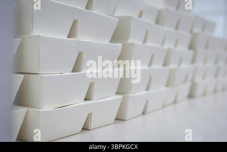 Scatola da asporto impilata e disposta in righe sul tavolo. Foto Stock