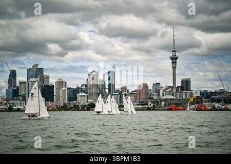 Barche a vela che corrono sul porto di Waitematā con lo skyline di Auckland e la Sky Tower sullo sfondo, nuova Zelanda Foto Stock