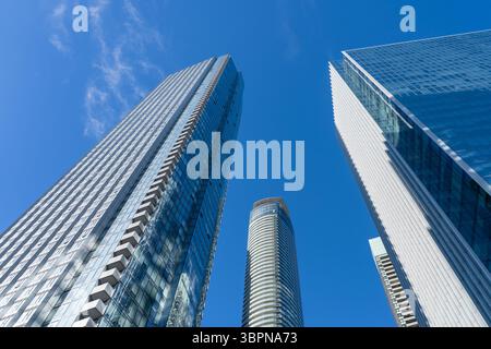 Affacciati su alti e moderni edifici residenziali e uffici con il cielo blu sullo sfondo nel centro di Toronto, Canada Foto Stock