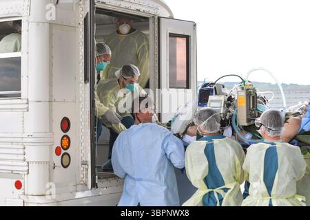 1 luglio 2020 - Ramstein Air base, Rheinland-Pfalz, Germania - gli aviatori assegnati al 86th Medical Group e al 313th Expeditionary Operations Support Squadron trasferiscono un paziente COVID-19 dopo il primo utilizzo operativo del Conex pressurizzato negativamente per trasportare 12 pazienti a bordo di un aereo C-17 Globemaster III presso Ramstein Air base, Germania, 1 luglio, per ricevere un livello di assistenza più elevato presso il Landstuhl Regional Medical Center, Germania. L'NPC è l'ultima camera di contenimento isolata sviluppata per trasportare fino a 28 persone con malattie infettive. (Immagine di credito: © John Wright/U.S. Foto Stock