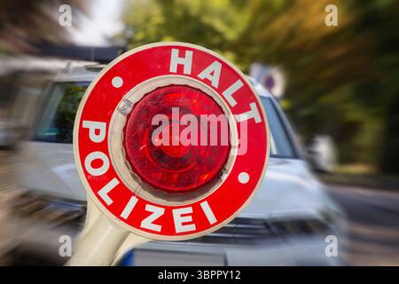 Fotomontage Symbolbild Polizeikontrolle: Nahaufnahme einer Polizeikelle mit der Aufschrift HALT POLIZEI vor einem PKW *** fotomontaggio immagine simbolica controllo di polizia primo piano di una cazzuola di polizia con l'iscrizione HALT POLIZEI di fronte a un'auto Copyright: XUdoxHerrmannx Foto Stock
