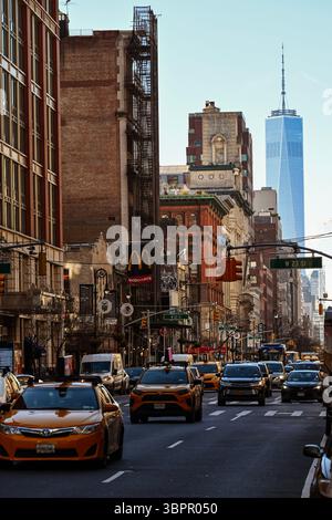 Ammira la trafficata Manhattan Street con il traffico e i taxi gialli, con sullo sfondo l'One World Trade Center, New York City, USA Foto Stock