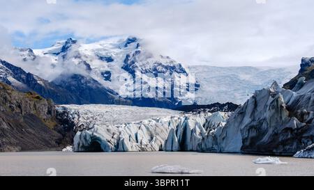 Il ghiacciaio Svinafellsjokull, situato in Islanda, affascina con le sue formazioni di ghiaccio uniche e lo sfondo montuoso mozzafiato. Questo splendido ghiacciaio attira sia gli amanti dell'avventura che gli amanti della natura. Foto Stock