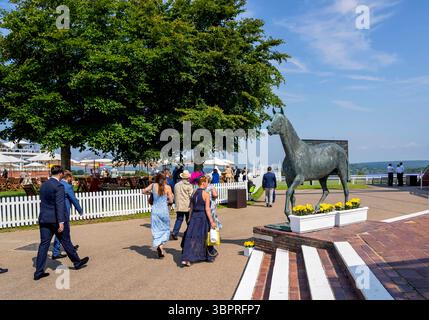 Incontro 2024 del Qatar Goodwood Festival presso l'ippodromo Goodwood di Chichester - Racegoers si dirigono verso la pista Goodwood Foto Stock