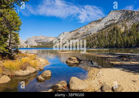 Splendida vista del lago Tenaya che riflette le montagne circostanti nel Parco Nazionale di Yosemite in una giornata di sole Foto Stock