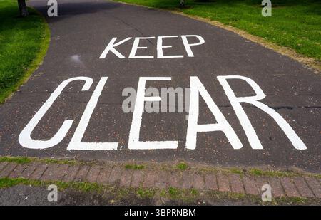 Mantenere un cartello trasparente verniciato su una strada, Regno Unito Foto Stock