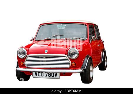 Mini Cooper rossa classica con tetto bianco isolato su sfondo bianco che mostra la vista anteriore e laterale ritagliata Foto Stock