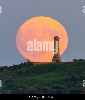 Portesham, Dorset, Regno Unito. 9 luglio 2025. Meteo nel Regno Unito. La luna Buck quasi piena si innalza nel cielo sereno da dietro l'Hardy Monument vicino a Portesham nel Dorset. Il monumento, a forma di telescopio, è stato costruito nel 1844 in memoria del viceammiraglio Sir Thomas Masterman Hardy che era Flag Captain della HMS Victory nella battaglia di Trafalgar. Crediti fotografici: Graham Hunt/Alamy Live News. Crediti fotografici: Graham Hunt/Alamy Live News Foto Stock