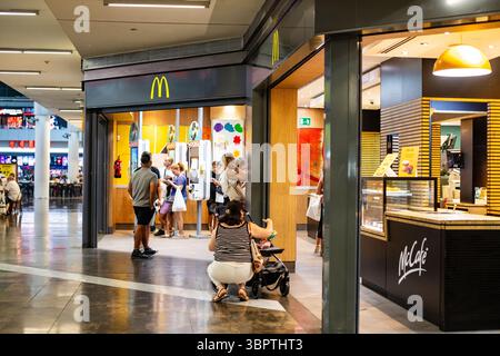 Ambiente moderno McCafé e ingresso McDonald's, vivace ristorante in un centro commerciale Barcellona Spagna 09.07.2025 Foto Stock