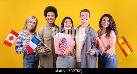 Smillinge studente multietnico in casual, tenere piccole bandiere Foto Stock