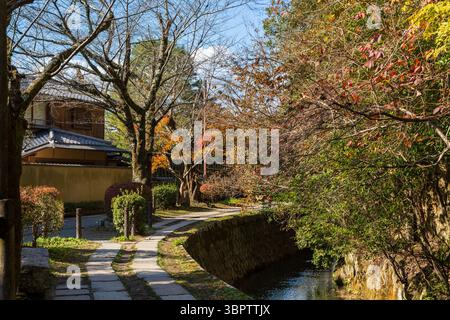 Il tranquillo sentiero dei filosofi (Tetsugaku no michi) a Kyoto, una passerella in pietra lungo un canale fiancheggiato da fogliame autunnale. Sakyo-ku, Kyoto, Giappone. Foto Stock