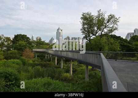 I passerelle sopraelevati del Parco Benjakitti nel centro di Bangkok offrono vedute panoramiche dello skyline della capitale Foto Stock
