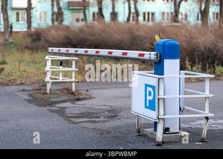 Barriera automatica per il parcheggio di un territorio privato. Tecnologie di sicurezza nella vita di tutti i giorni. Segnale di parcheggio. Foto Stock