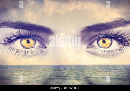Design digitale surreale che mostra occhi dorati-gialli che si fondono con l'orizzonte calmo dell'oceano e il cielo nuvoloso Foto Stock