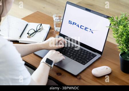 Poznan, Polonia - 15 giugno 2025: Vista a spalla di una persona che utilizza un laptop con il logo SpaceX sullo schermo, evidenziando i progressi nel settore delle Foto Stock