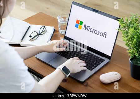 Poznan, Polonia - 15 giugno 2025: Branding Microsoft su un laptop, utilizzato attivamente da una persona per il lavoro digitale, simboleggiando il software aziendale e la busine Foto Stock