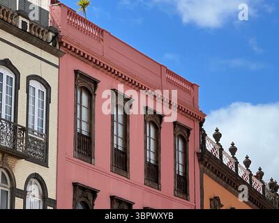 Las Palmas, Isole Canarie, Spagna - marzo 13, 2022. Uno splendido edificio rosa con intricati dettagli architettonici si erge su un cielo blu luminoso. Foto Stock