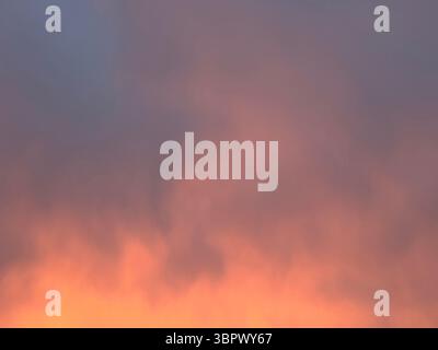 Il cielo dipinge una splendida tela di colori caldi durante il tramonto o l'alba. Foto Stock