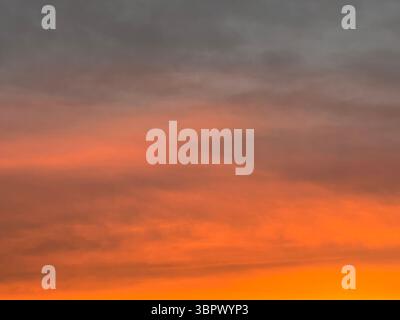 Uno splendido tramonto dipinge il cielo con splendide sfumature di arancione e grigio. Foto Stock
