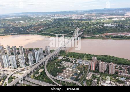 (250710) -- CHONGQING, 10 luglio 2025 (Xinhua) -- questa foto del drone aereo scattata il 3 luglio 2025 mostra la vista dell'area urbana nel distretto di Jiangjin, nel comune di Chongqing della Cina sud-occidentale. Jiangjin si trova in un punto strategico lungo il fiume Yangtze. Gli edifici cittadini sono stati costruiti lungo le pendici sulle rive del fiume. Da lontano, sembrano una foresta che cresce dalle scogliere. Negli ultimi anni, Jiangjin ha promosso la gestione ecologica del fiume Yangtze. Il miglioramento della qualità dell'acqua ha attratto le specie ittiche rare a ritornare. (Xinhua/Huang Wei) Foto Stock
