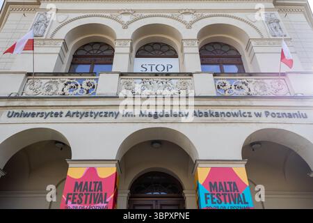 Poznan, Polonia - 18 giugno 2025: Università delle Arti con balcone ornato, sculture e vivaci striscioni del Festival di Malta Foto Stock