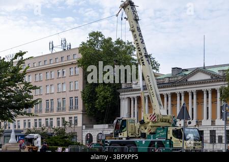 Poznan, Polonia - 18 giugno 2025: Una gru mobile STROZYK Liebherr con il suo braccio esteso vicino a Biblioteka Raczynskich, che illustra il sollevamento pesante e urb Foto Stock