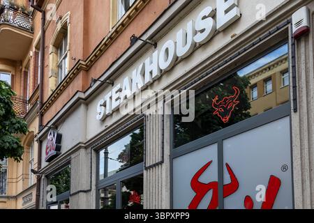 Poznan, Polonia - 18 giugno 2025: Facciata del ristorante Evil Steakhouse con il suo esclusivo cartello rosso toro al neon e il grande logo del marchio Foto Stock