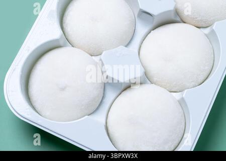 Mochi di gelato al mango giapponese su sfondo verde Foto Stock