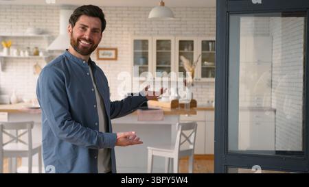 Allegro felice uomo caucasico papà sorridente gesto con le mani invitando a nuova casa casa padre maschio adulto felice venire dentro per il gesto di visita Foto Stock