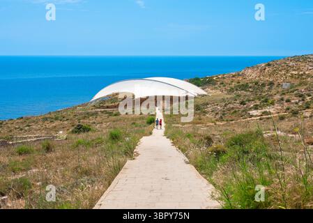 Tempio megalitico di Malta, vista del breve percorso che dal sito di Hagar Qim conduce alle rovine del tempio neolitico di Mnajdra (protetto da una cupola protettiva) Foto Stock