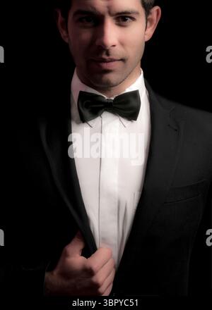 Un uomo in un smoking adatta la sua giacca. Foto Stock