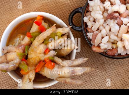 zuppa di pollo servita con zuppa e fagioli. si tratta di una vista dall'alto verso il basso, con le ciotole su una superficie rustica Foto Stock