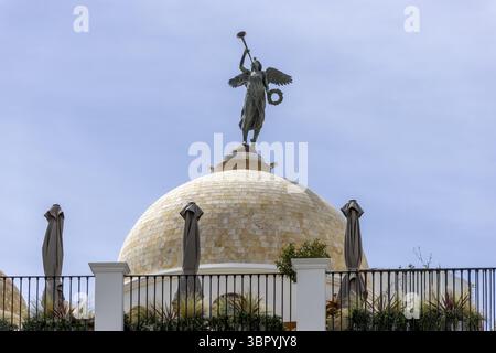 Edificio impressionante con una cupola semicircolare con una scultura in bronzo accanto a Plaza de las Flores, nel centro storico di casco Antiguo, Estepon Foto Stock