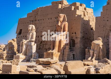 Statue giganti al terzo pilone raffigurano faraoni, Thutmose III, Amenhotep i e Thutmose II, complesso del tempio di Karnak, Luxor Foto Stock