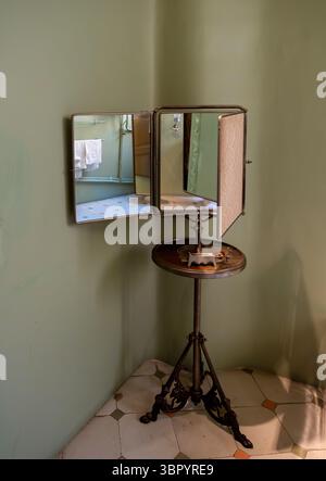 Un antico specchio regolabile per la rasatura su un cavalletto nel bagno dello storico appartamento di Casa Milà (la Pedrera), Barcellona, Spagna. Foto Stock