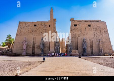 Vista del primo pilone del tempio di Luxor con l'imponente statua di Ramses II, Egitto Foto Stock